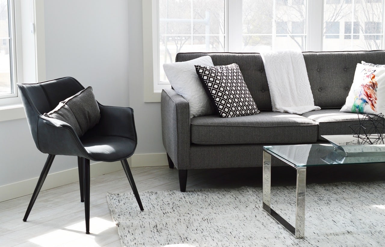 Bright apartment living room with large windows and a gray sofa