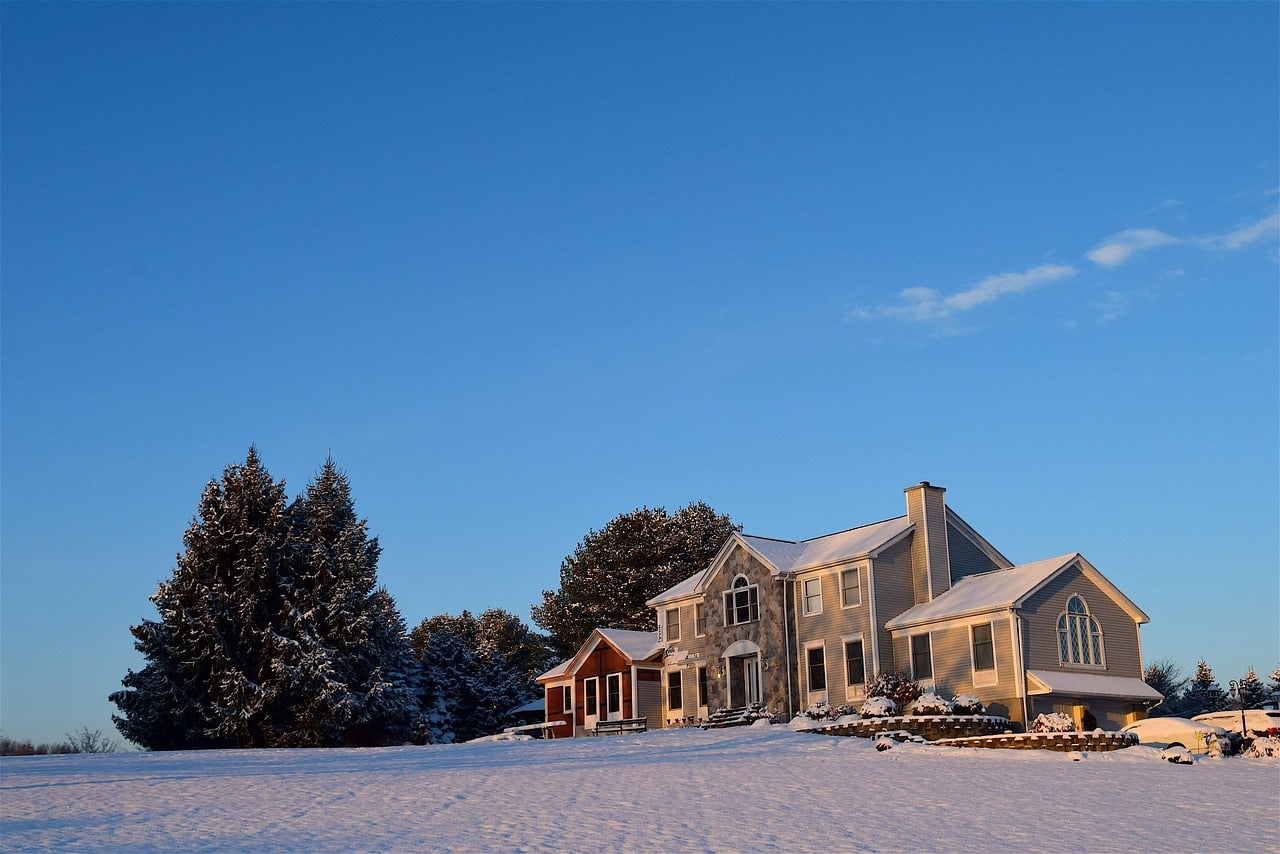 Snow-covered house lit by low winter sunlight