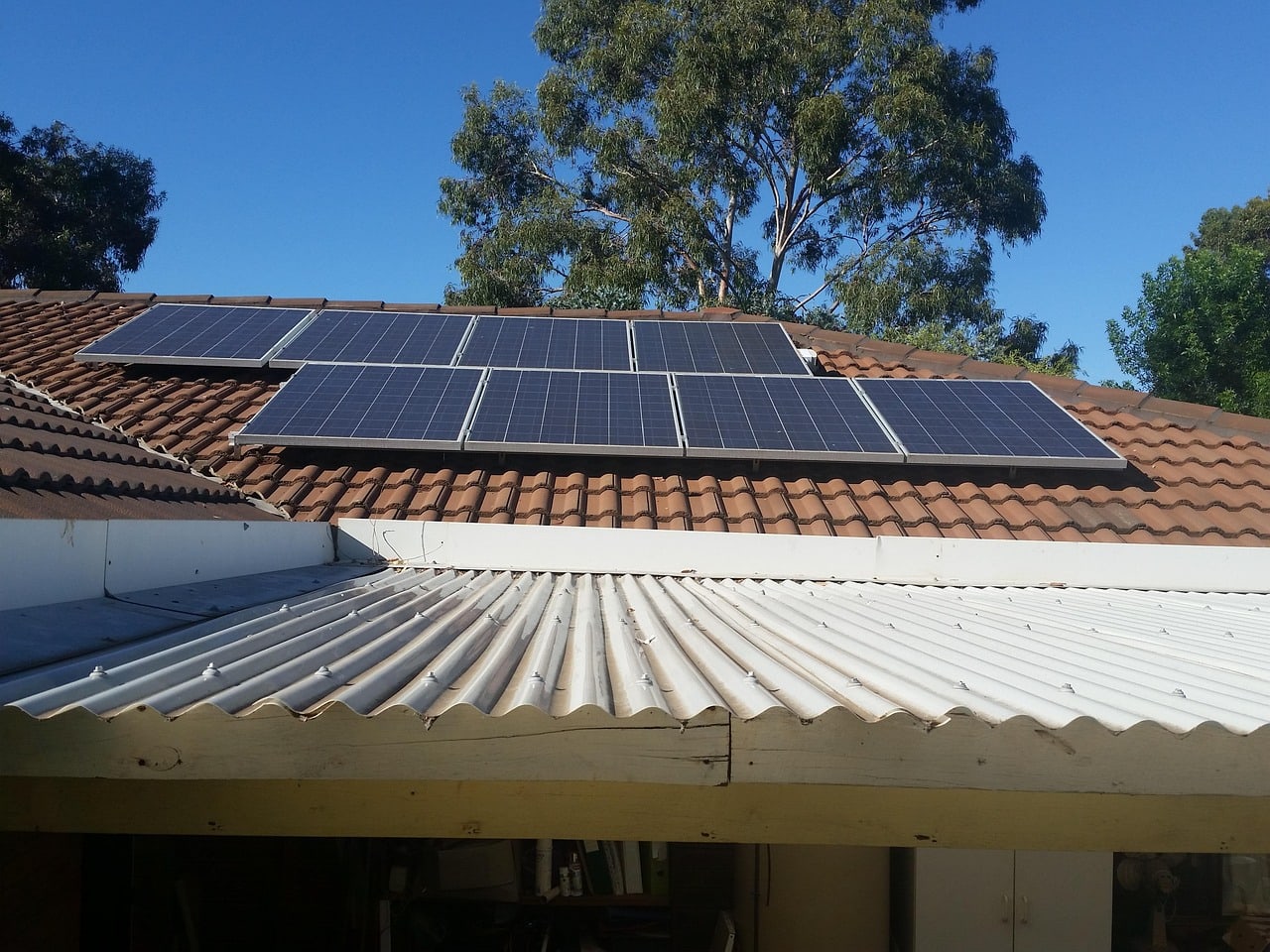 Solar panels on a tiled roof with trees nearby