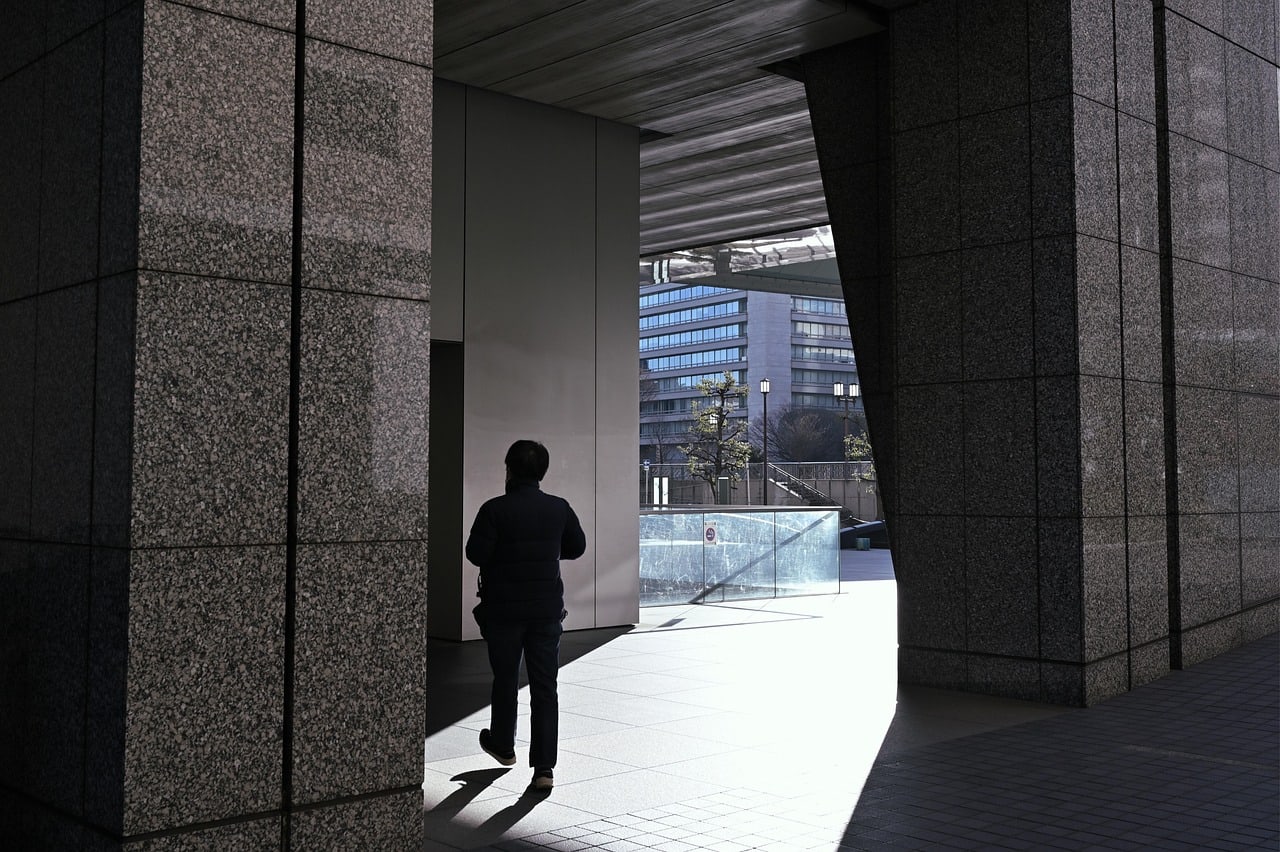 Strong sunlight casting a sharp shadow across a modern building facade, illustrating why sun direction matters in architectural photography