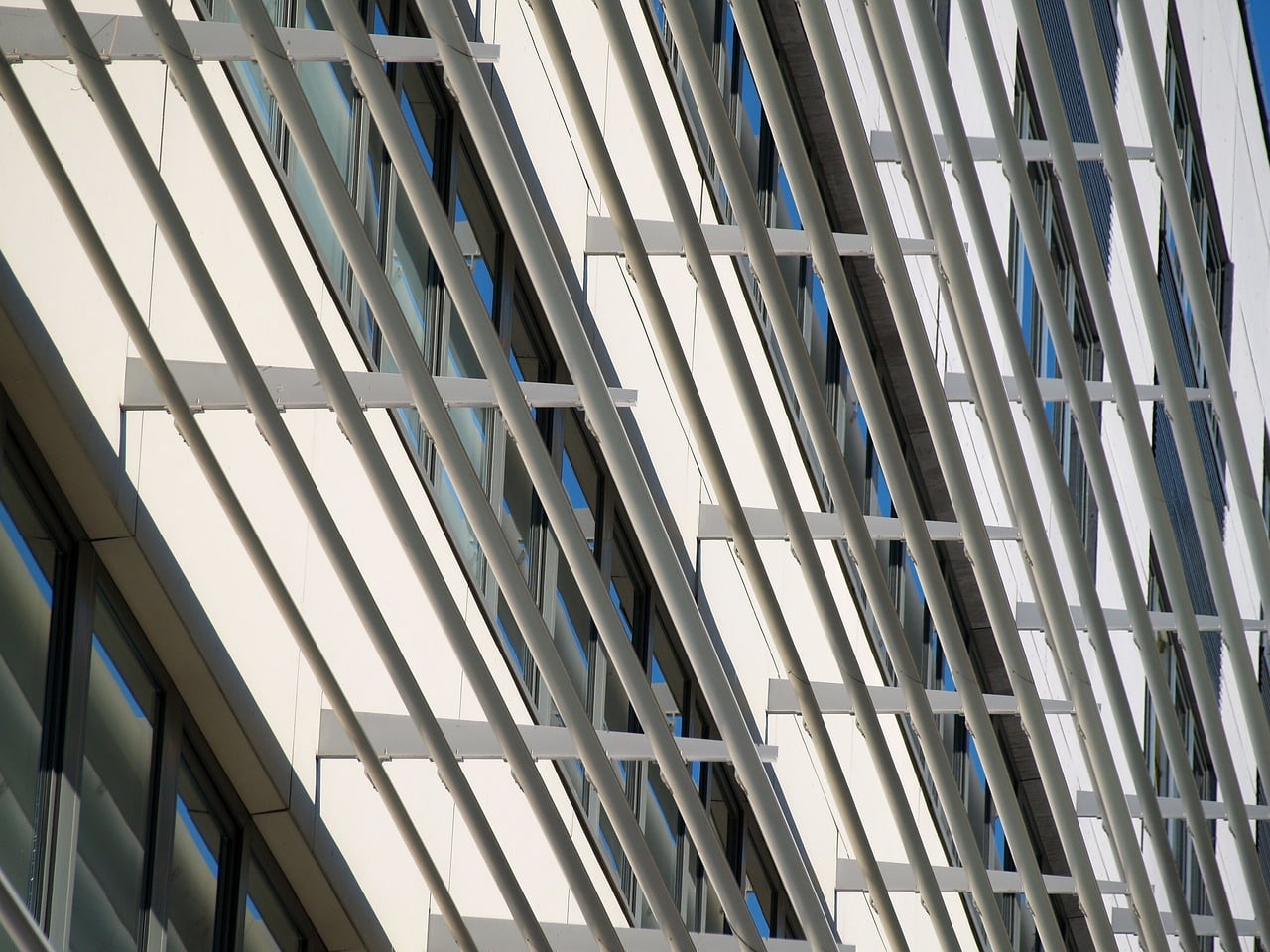 Rows of exterior metal shading blades projecting in front of a building’s windows